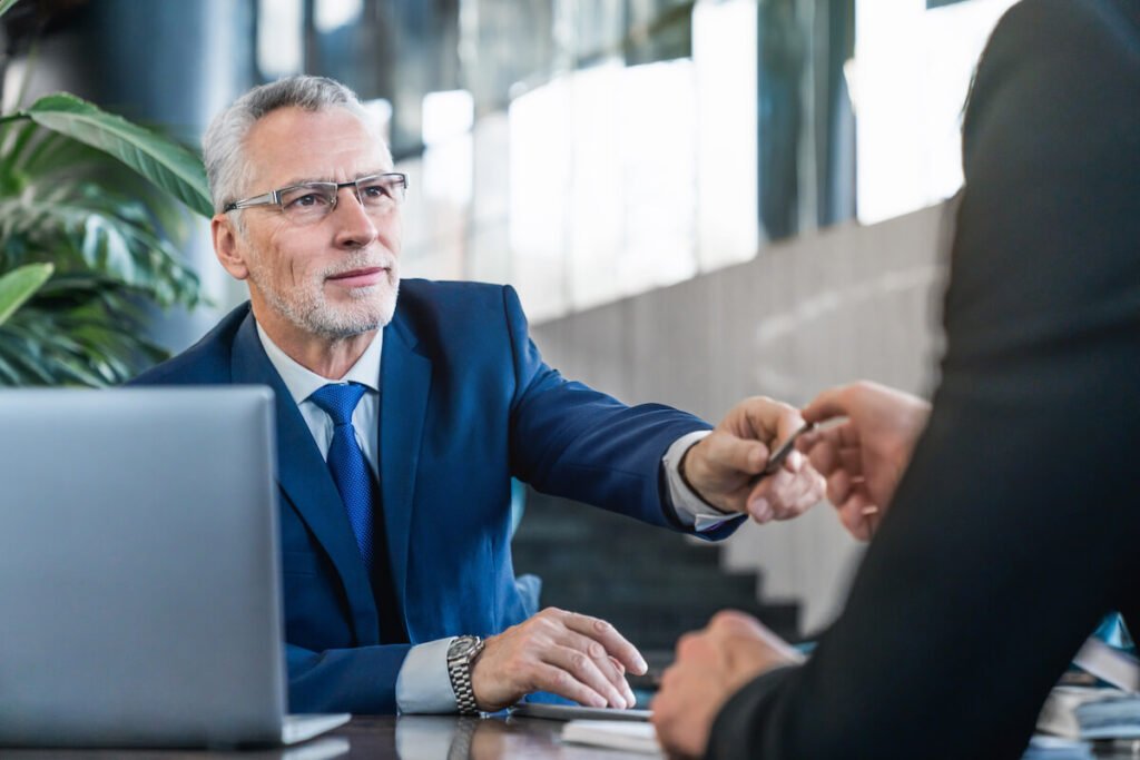 Ejecutivo dando bolígrafo a cliente
